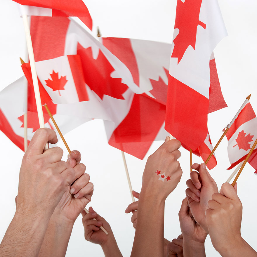 A group of people holding up Canada Flags.