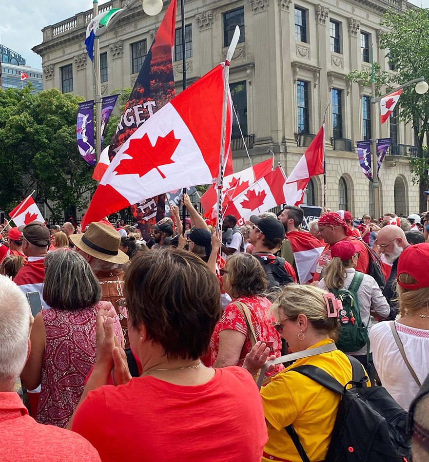 A bunch of people waving flags on Canada Day.